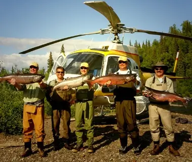 fisherman with their catch in front of a helicopter, Alaska