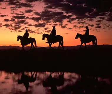 cowboys horseback riding at sunset in Latigo Ranch, Kremmling, CO