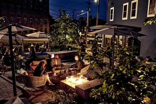 Группа друзей собралась на заднем дворике бара/ресторана.