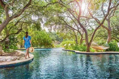 Женщина идет вдоль ленивой реки в отеле Hyatt Regency Hill Country.