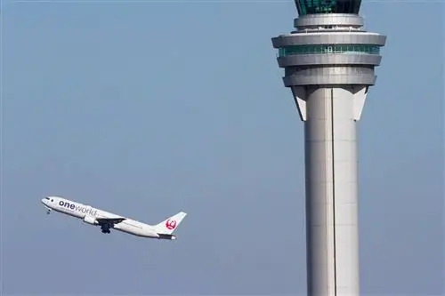 Boeing 767-300 Japan Airlines (JAL) в ливрее One World взлетает за диспетчерской вышкой в международном аэропорту Ханеда.