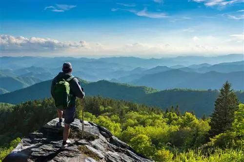 Турист, стоящий на вершине горы и наслаждающийся красивым осенним пейзажем. Рядом с Эшвиллом, Северная Каролина