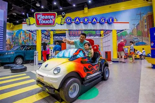 Отец и сын в игрушечной машине в музее Please Touch