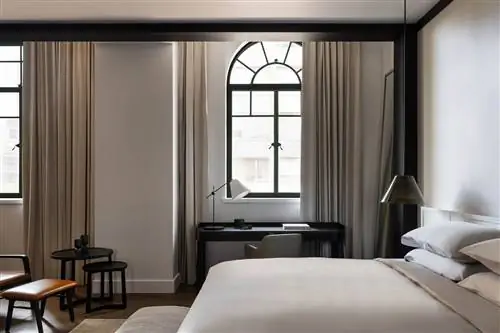 Кровать и рабочее место в номере Deluxe в Capella Sydney, роскошном отеле в Австралии