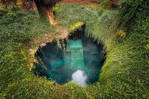 Глядя вниз на Логово Дьявола во Флориде, болотную яму с голубой водой.
