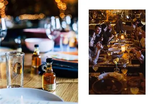 Бутылки кленового сиропа Palmer's Sugarhouse на столе и толпы людей, которые едят вокруг стола в Palmer's Sugarhouse.