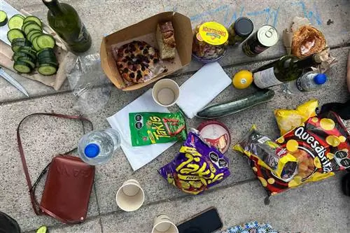 Бутылки вина и легкие закуски едят и делят на тротуаре в Мехико.