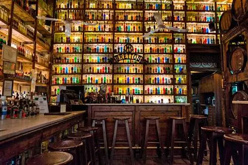 Подсвеченные полки со спиртными напитками в баре в Афинах, Греция.