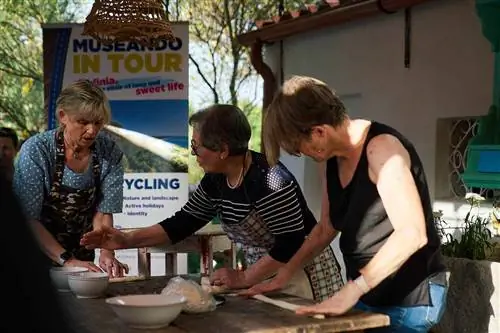 Группа на велосипедном туре Sardinia Chef Bike Tour берет урок кулинарии.