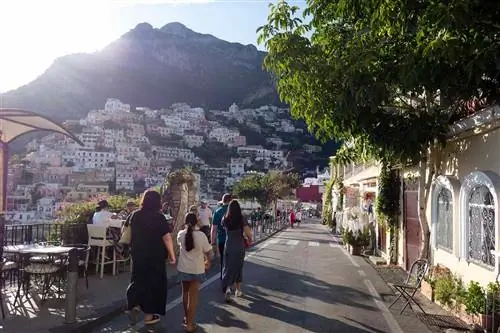 Люди идут по холмистым улицам Позитано, Италия