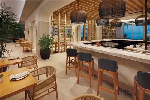 Внутреннее обеденное пространство и бар в ресторане Oia, являющемся частью Goldwynn Resort & Residences.