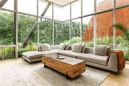 Окна от пола до потолка вдоль двух стен с большим диваном в Airbnb Houseplant Сета Рогана в Лос-Анджелесе.