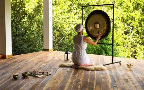 Женщина играет в гонг на ретрите Sen Wellness в Шри-Ланке.