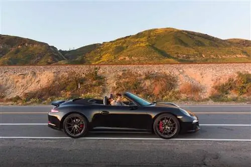 Porsche с вождением сверху вниз на фоне гор