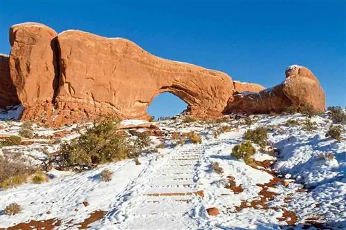 Заснеженная лестница на тропе к скальной формации North Window Arch в национальном парке Арки в штате Юта.