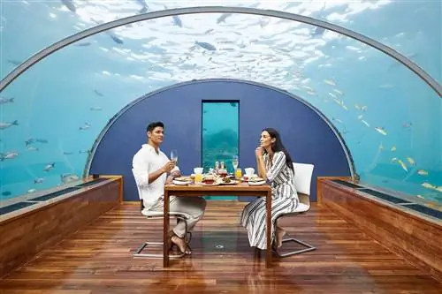 Пара обедает в подводном ресторане Ithaa отеля Conrad Maldives Rangali Island, Мальдивы.
