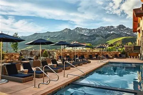 Летний вид на бассейн с горами на заднем плане в отеле Madeline Hotel and Residences, Auberge Resorts Collection