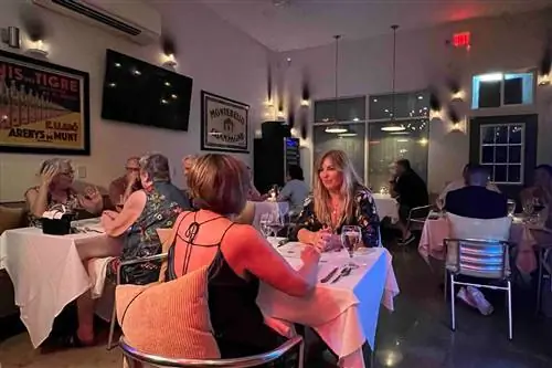 Люди обедают внутри nyloS