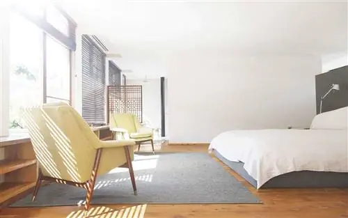 Кресла, ковер и кровать в современной спальне