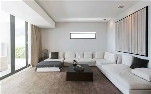 Вид на современную гостиную с диванами, журнальным столиком и абстрактной живописью