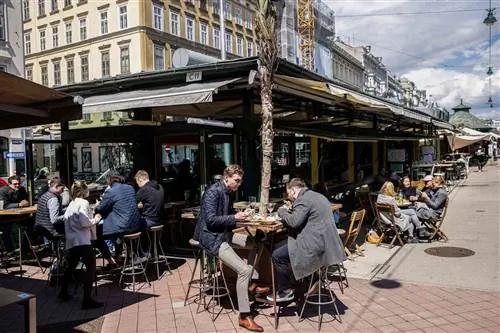 Клиенты обедают на открытой площадке ресторана на рынке Нашмаркт в Вене, Австрия, в четверг, 20 мая 2021 года.