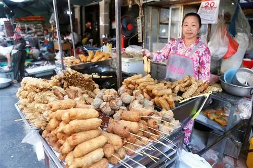 Продавец показывает закуски в киоске с уличной едой в Пномпене, Камбоджа, 20 февраля 2021 года.