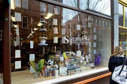 Прохожий проверяет книжный магазин Sherman's Books.