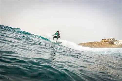 Серфер Хаджоу Самбе катается на волне