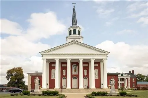 Католическая церковь в Бардстауне, штат Кентукки, построена из красного кирпича с высоким белым шпилем и колоннами.