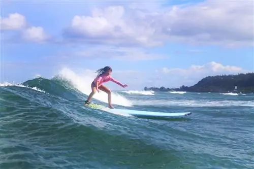 Маленькая девочка занимается серфингом с North Shore Surf Girls. Маленькая девочка занимается серфингом с North Shore Surf Girls.