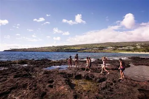 Дети играют на камнях у океана в Four Seasons Lanai Дети играют на камнях у океана в Four Seasons Lanai