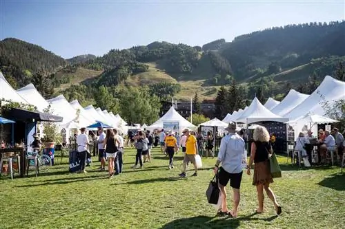 Люди ходят по территории между белыми палатками на Food & Wine Classic в Аспене.