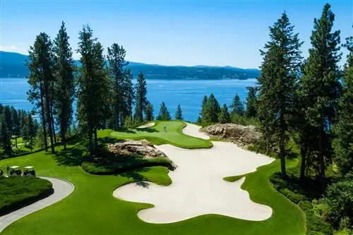 Поле для гольфа у воды с высокими соснами на курорте Coeur d'Alene Resort, Айдахо. Поле для гольфа у воды с высокими соснами на курорте Coeur d'Alene Resort, Айдахо.