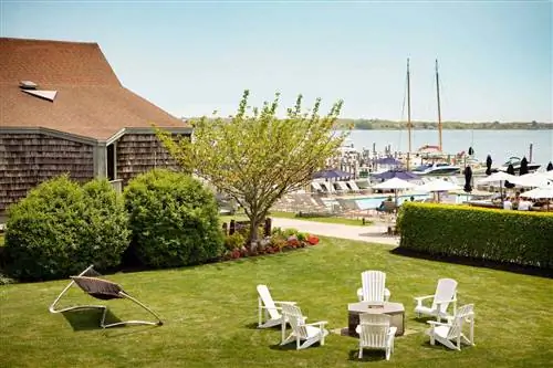 Адирондакские стулья вокруг костровой ямы в Gurney's Star Island Resort & Marina, признанном одним из лучших курортов в штате Нью-Йорк.