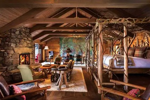 Деревянный и каменный интерьер комнаты для гостей в Lake Placid Lodge, признанном одним из лучших курортов в штате Нью-Йорк.