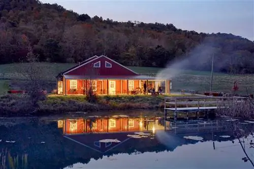 Красно-белый фасад сидрового зала Hawk Knob в Западной Вирджинии, освещенный ночью