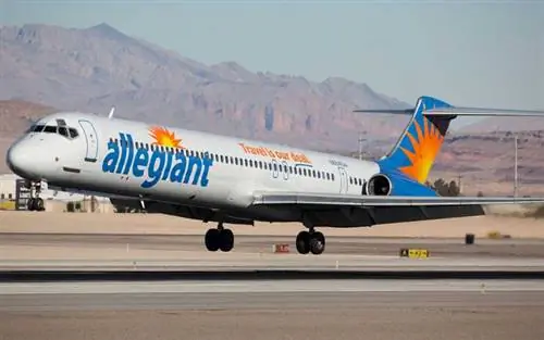 Самолет Allegiant Airlines взлетает с взлетно-посадочной полосы аэропорта с горами на расстоянии