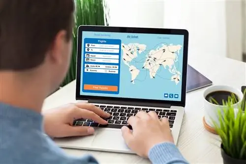 человек сидит с ноутбуком с приложением поиска авиабилетов