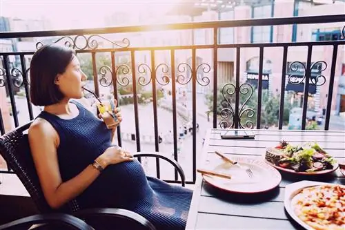 Беременная женщина ест в ресторане