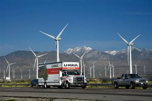 Грузовик U-Haul и другие транспортные средства едут по межштатной автомагистрали 10 и ветряной электростанции Сан-Горгонио-Пасс недалеко от Палм-Спрингс, Калифорния.