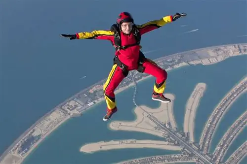 Парашютистка свободно летает над дубайской пальмой