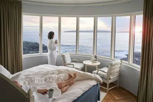 Пара наслаждается видом на Торсхавн и Фарерские острова из своего номера в отеле Havgrim Seaside.