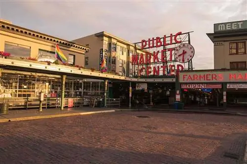 Знаменитая неоновая вывеска Public Market Center на рынке Пайк-плейс на закате с флагами ЛГБТ. Знаменитая неоновая вывеска Public Market Center на рынке Пайк-плейс на закате с флагами ЛГБТ.