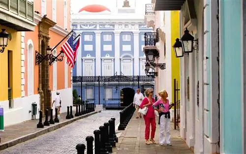 Туристы исследуют улицу, ведущую к Ла-Форталезе, также называемому Паласио-де-Санта-Каталина, особняку губернатора в Старом Сан-Хуане, Пуэрто-Рико.