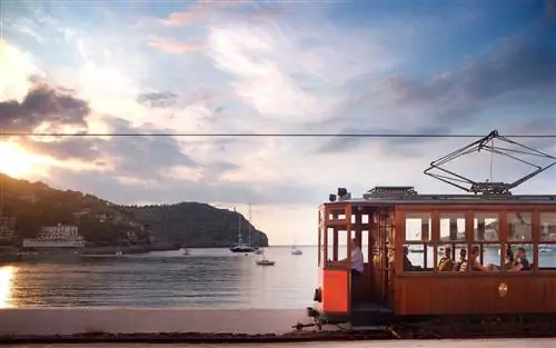 Трамвай на закате против яхт в бухте, Сольер, Майорка, Балеарские острова, Испания