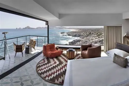 Люкс с балконом, кроватью, телескопом и видом на скалы и воду.
