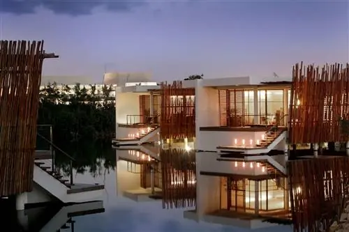 Люксы в лагуне ночью в Rosewood Mayakoba, роскошном курорте в Мексике.