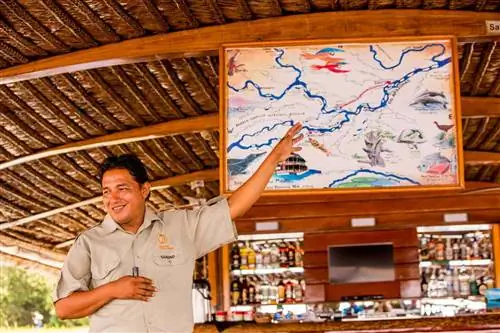 Гид показывает маршрут круиза Delfin Amazon Cruise.