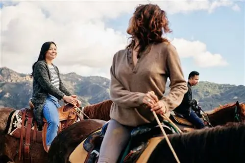 Люди верхом на лошадях на фоне гор