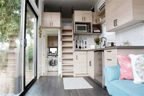 Интерьер крошечного дома с большими стеклянными окнами, витринными кухней, гостиной и спальней в стиле лофт.